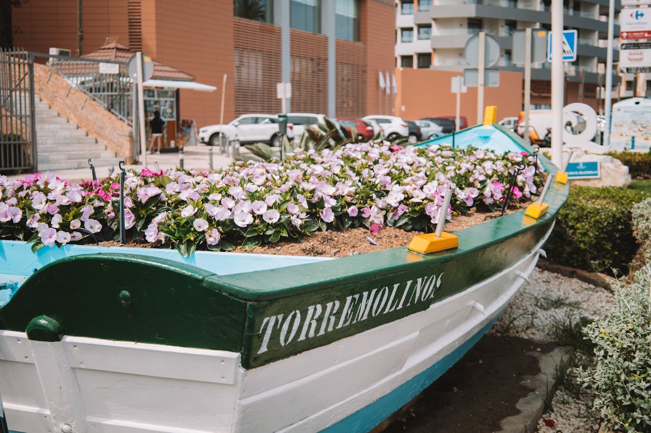 Crafting Captivating Headlines: Your awesome post title goes here A vibrant boat planter filled with flowers, set in an urban area in Torremolinos, Spain.